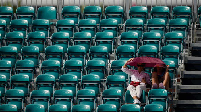 Two fans sit among empty seats at the Miami Open.
